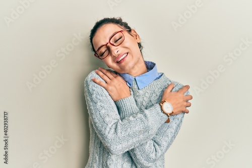 Young caucasian woman wearing casual clothes and glasses hugging oneself happy and positive, smiling confident. self love and self care © Krakenimages.com