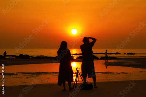 Hua Hin, Thailand - October 24, 2020: Man and Women silhouette standing while shootingon a beach in Hua Hin, Thailand.