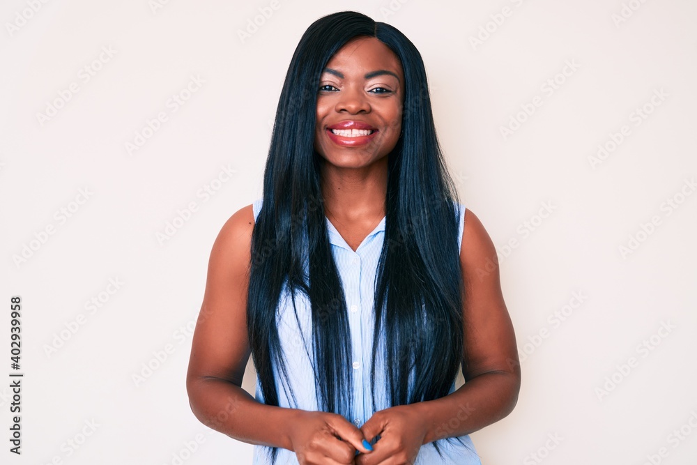 Fototapeta premium Young african american woman wearing casual clothes looking positive and happy standing and smiling with a confident smile showing teeth