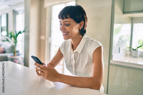 Free Download Beautiful brunette woman with short hair at home using smartphone - GFXLoad