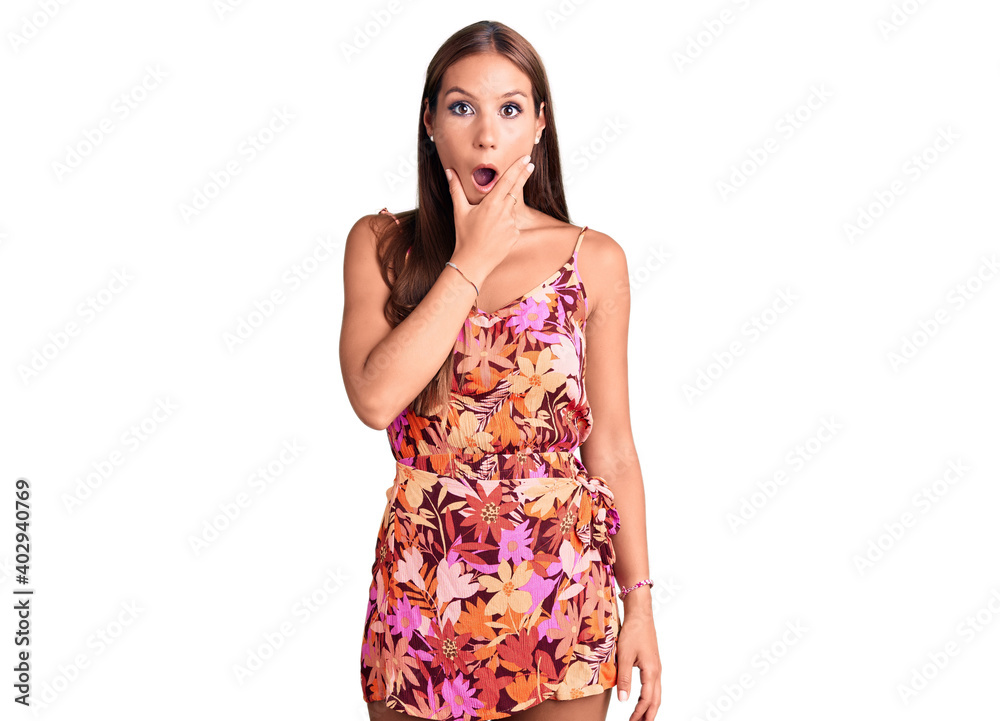 Young beautiful hispanic woman wearing casual clothes looking fascinated with disbelief, surprise and amazed expression with hands on chin Young beautiful hispanic woman wearing casual clothes looking fascinated with disbelief, surprise and amazed expression with hands on chin