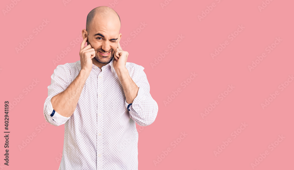 Young handsome man wearing elegant shirt covering ears with fingers with annoyed expression for the noise of loud music. deaf concept. Young handsome man wearing elegant shirt covering ears with fingers with annoyed expression for the noise of loud music. deaf concept.