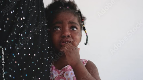 African American little girl is crying and stand near her mother and look around with stay on her house. Concept of sad emotion of children should support by family.