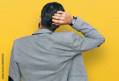 Young hispanic man wearing business clothes backwards thinking about doubt with hand on head © Krakenimages.com