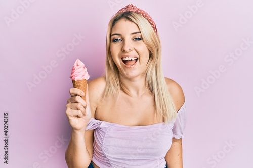 Young caucasian woman holding ice cream smiling and laughing hard out loud because funny crazy joke.