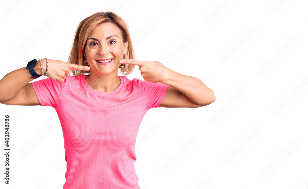 Fototapeta premium Young blonde woman wearing sportswear smiling cheerful showing and pointing with fingers teeth and mouth. dental health concept.