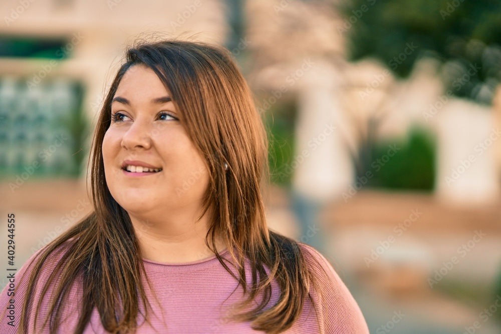 Obraz premium Young hispanic plus size woman smiling happy standing at the city.