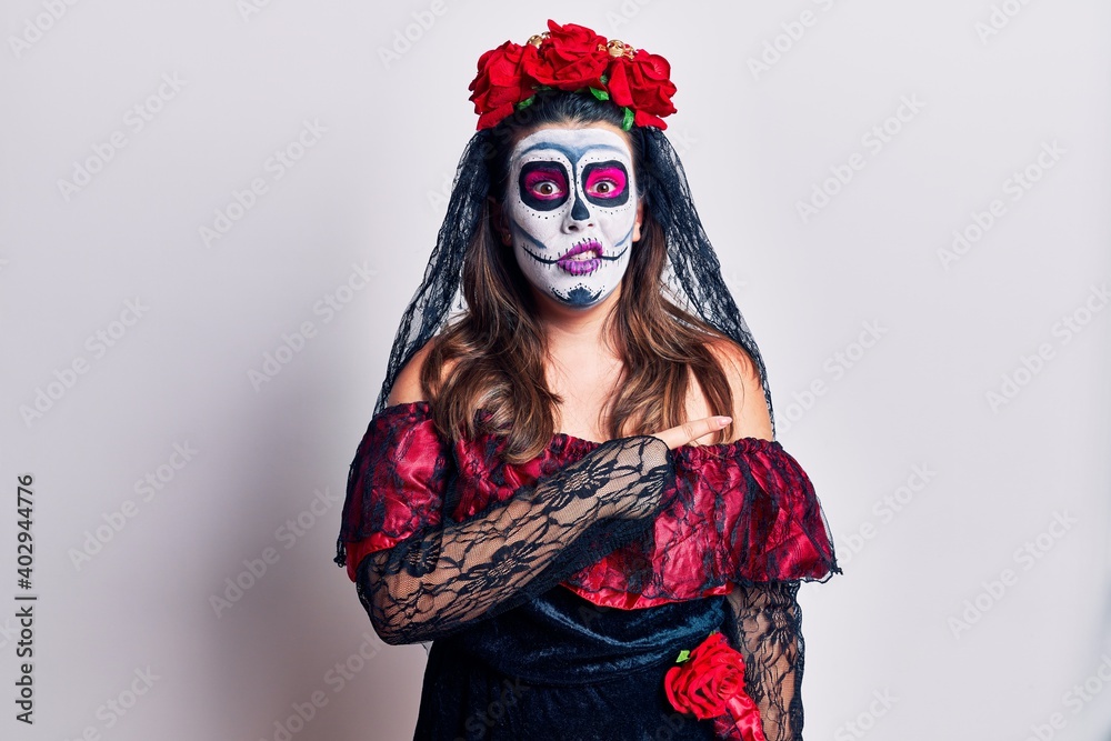 Young woman wearing day of the dead costume over white pointing aside worried and nervous with forefinger, concerned and surprised expression