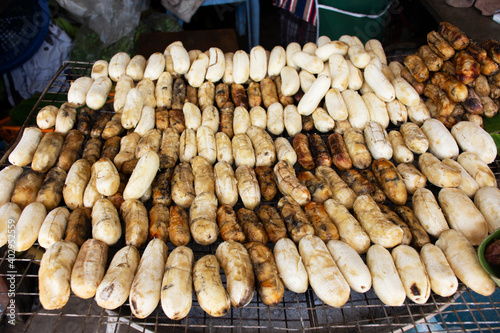Pisang Awak or Cultivated bananas grilled roasted with coat honey on local coal stove for sale thai people and foreign travelers at antique vintage retro market baan madua in Nong Bua Lamphu, Thailand photo