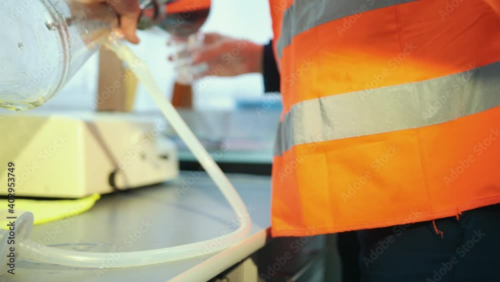 Close up. Young attractive female scientist work with liquid substance