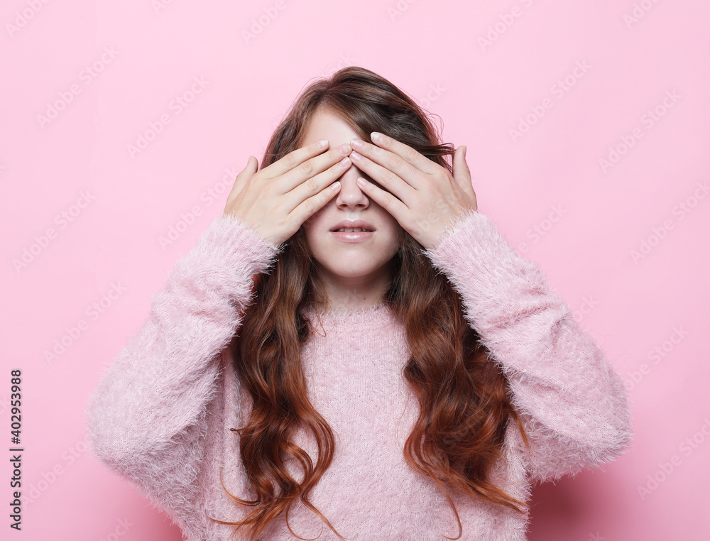 Adorable little girl with long curly blond hair closes her eyes with her palm Adorable little girl with long curly blond hair closes her eyes with her palm