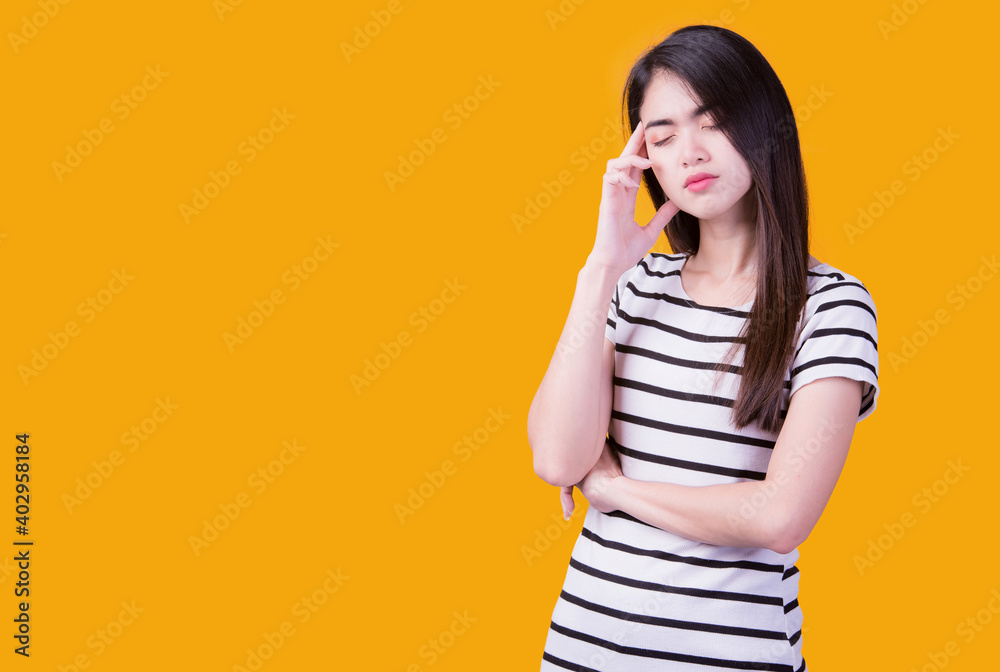 Smiling asian woman pointing up and looking at the camera over yellow background Smiling asian woman pointing up and looking at the camera over yellow background