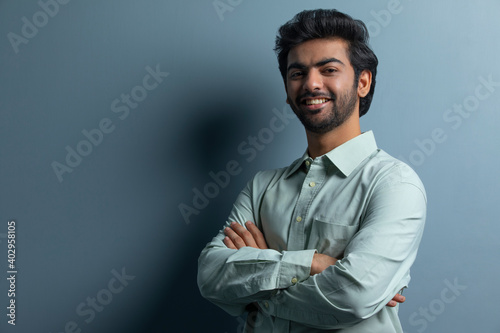 A YOUNG EXECUTIVE HAPPILY POSING IN FRONT OF CAMERA 