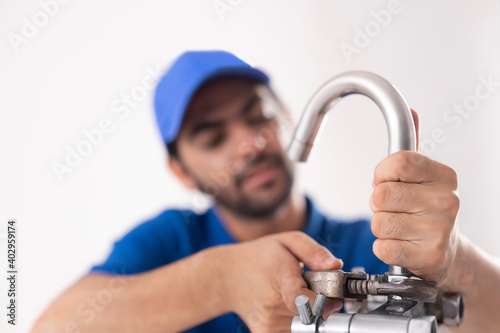 A BROKEN PIPE BEING FIXED BY A YOUNG PLUMBER	 photo