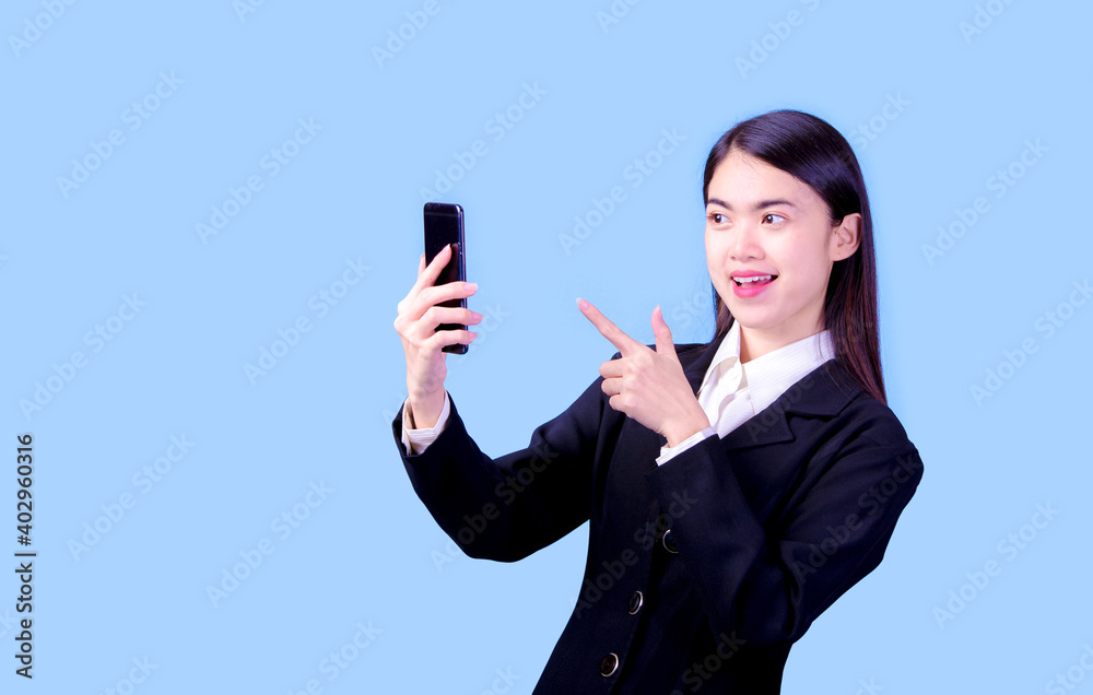 Portrait of Asian woman, happy working day.beautiful modern businesswoman ,holding mobile phon on blue background in the studio Portrait of Asian woman, happy working day.beautiful modern businesswoman ,holding mobile phon on blue background in the studio