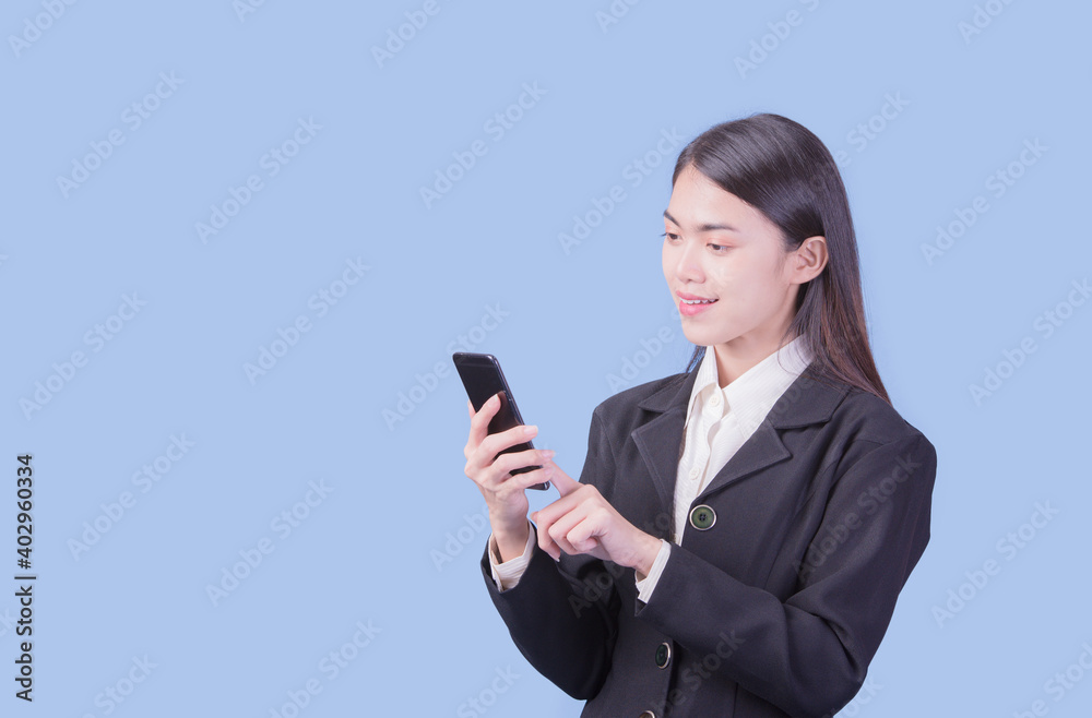 Portrait of Asian woman, happy working day.beautiful modern businesswoman ,holding mobile phon on blue background in the studio Portrait of Asian woman, happy working day.beautiful modern businesswoman ,holding mobile phon on blue background in the studio