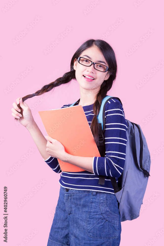 Portrait of a female student weaving two braids and wearing glasses having fun returning to school