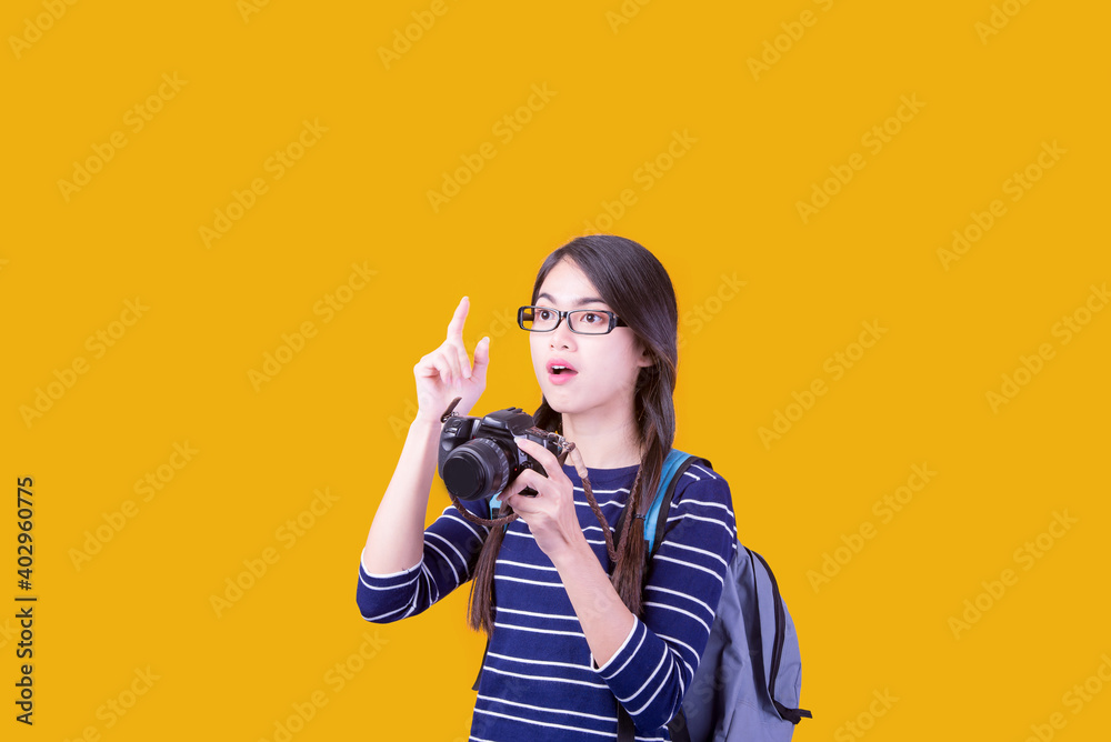 Asian woman tourist was running her to various places.happy excited emotional young woman photographer tourist standing isolated over Orange background