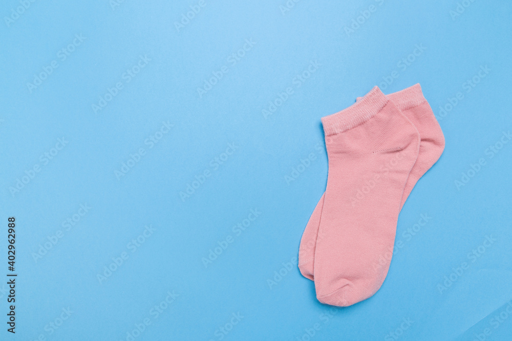 pink new socks stacked on a blue background. top view. pink new socks stacked on a blue background. top view.