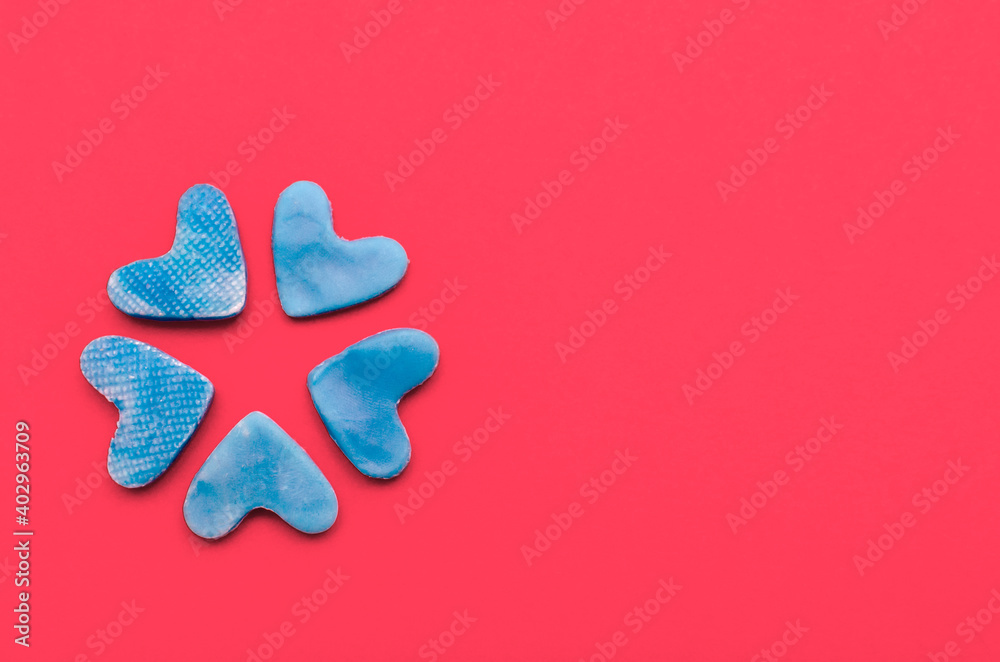 Obraz premium Blue hearts on red background.