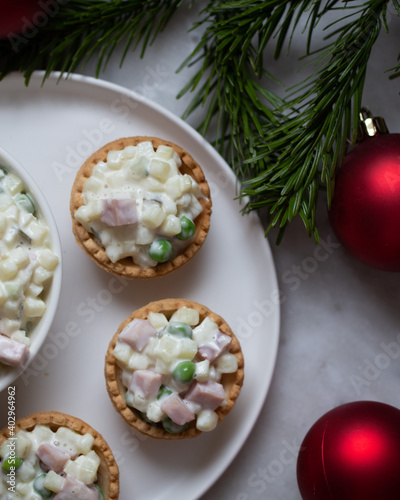 Traditional Russian salad Olivier in tartlets and Christmas decorations