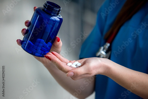  doctor hand is holding white pills and antibiotic covid-19