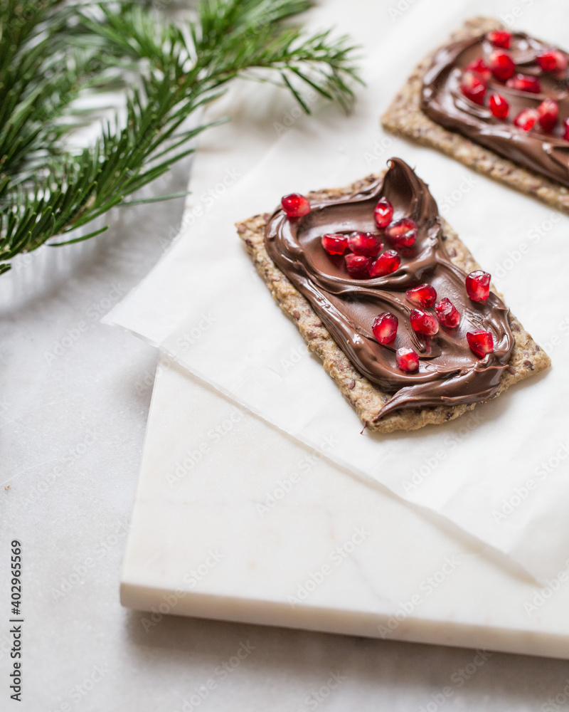 pomegranate sandwich with chocolate paste on christmas background pomegranate sandwich with chocolate paste on christmas background