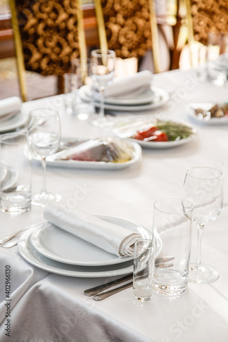 Table setting. Restaurant Served table for party in light neutral colors © Olga Mishyna