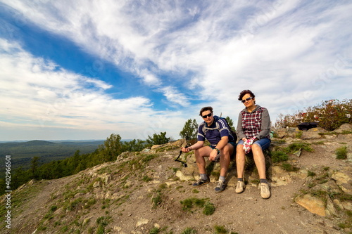 hikers men and women sit on top of mountain sugomak on summer sunny day photo