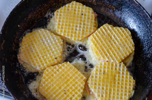 Traditional morning meal. Frying raw brizoles in waffle crusts. photo