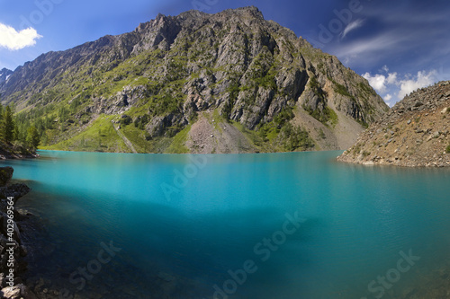 A beautiful lake in a mountain valley. Mountains, sky with clouds. Natural background.