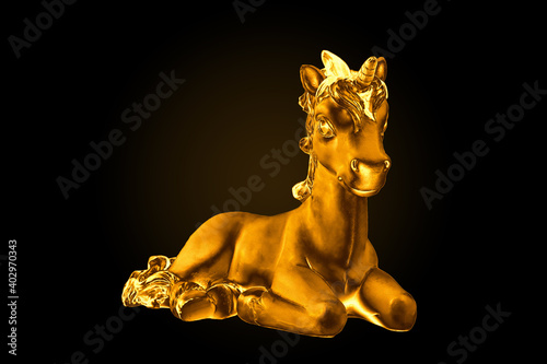 The Golden statue of a unicorn on a black background. Minimalism.