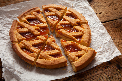 detail of sliced apricot tart over wooden table