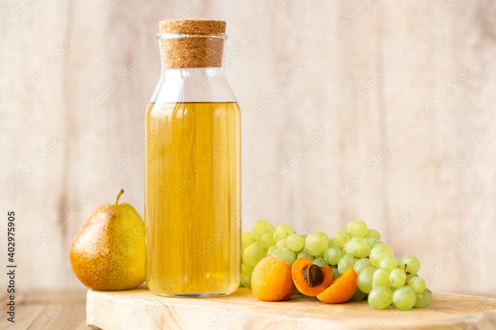 Homemade white wine or apple cider vinegar in a tall bottle with a wooden stopper. Homemade white wine or apple cider vinegar in a tall bottle with a wooden stopper.