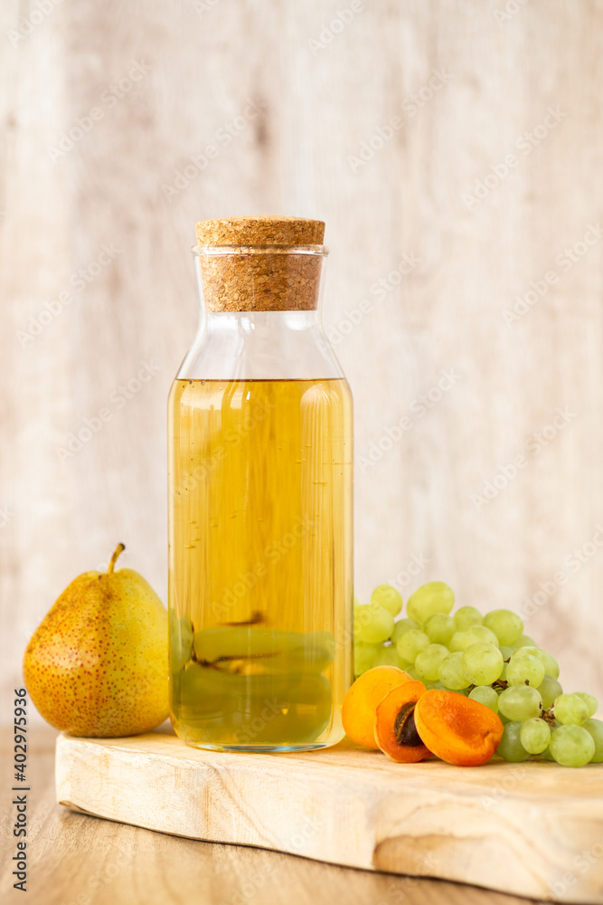 Homemade white wine or apple cider vinegar in a tall bottle with a wooden stopper. Homemade white wine or apple cider vinegar in a tall bottle with a wooden stopper.