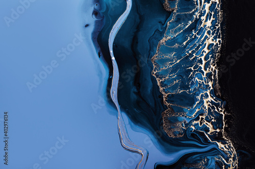 Acrylic Fluid Art. Dark blue waves in abstract ocean and golden foam. Marble effect background or texture