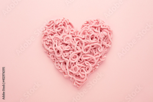 Valentines Day Heart made of yarn on pink background. Copy space  Flat lay. Compound love symbol.
