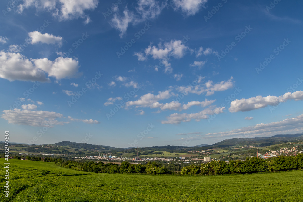 Views of the hills and surrounding city with views of the surrounding hills in the background of a blue sky with white clouds.