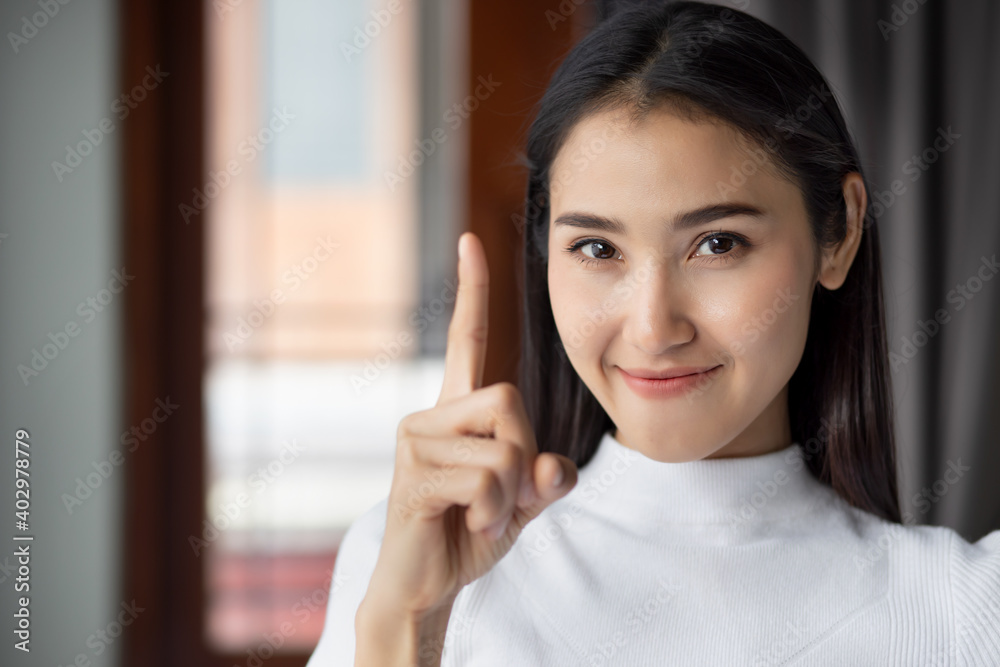 asian woman pointing up confident winning one finger sign, portrait of happy smiling asian woman pointing up 1 finger for number one or first point leader concept asian woman pointing up confident winning one finger sign, portrait of happy smiling asian woman pointing up 1 finger for number one or first point leader concept
