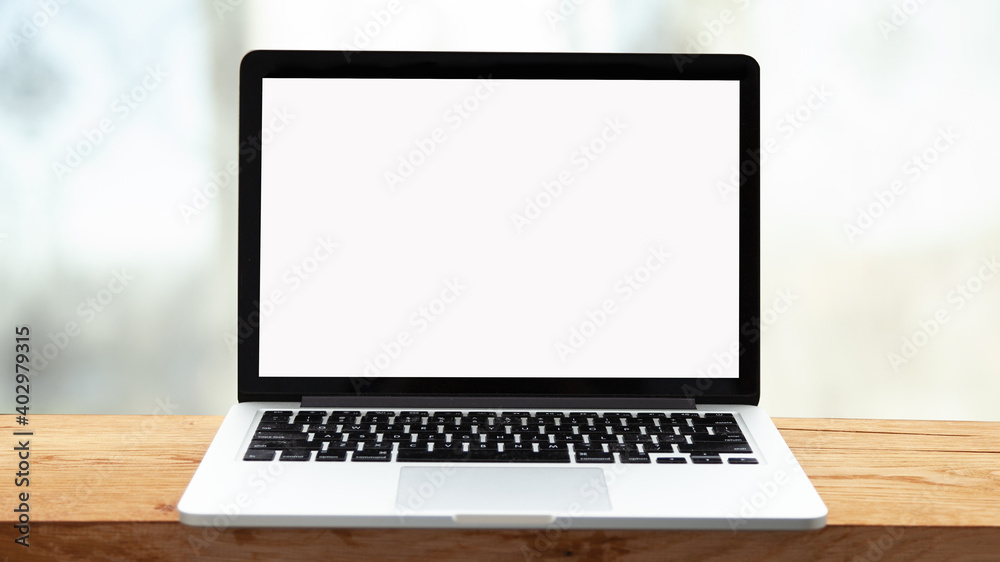 Laptop or notebook with blank screen on wooden table in blurred background in modern home or office, bokeh light and sunlight in the morning. Laptop or notebook with blank screen on wooden table in blurred background in modern home or office, bokeh light and sunlight in the morning.