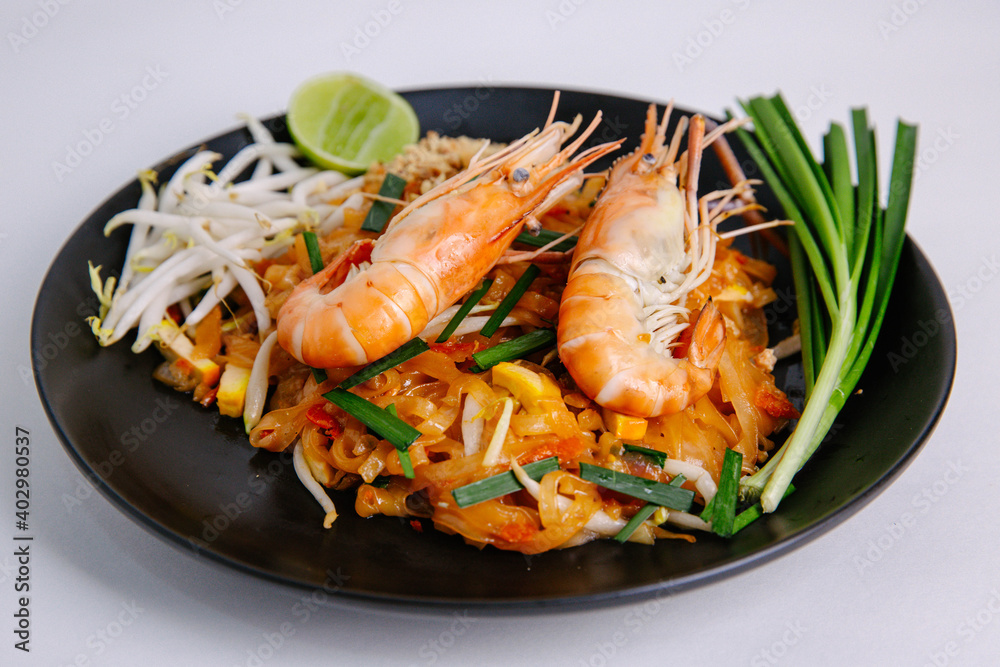 Udon Pad Thai Shrimp Black Plate White background Asian food Udon Pad Thai Shrimp Black Plate White background Asian food