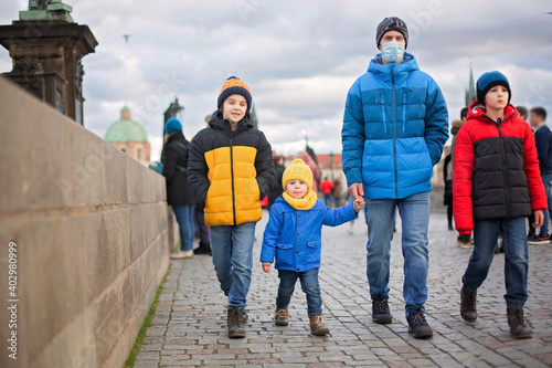 Cute child, boy with family, having a walk in Prague on Charles bridge wintertime