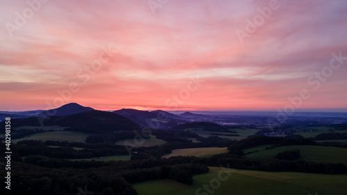 Aerial view of colorful clouds and mountainous hilly landscape at sunset over the horizon of Beskydy region. © Lukas
