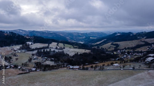 Aerial view of a hilly landscape with freshly fallen snow during a light snowfall in the Beskydy region. © Lukas