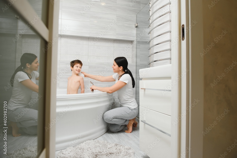 Mother washing little son in bathroom Mother washing little son in bathroom