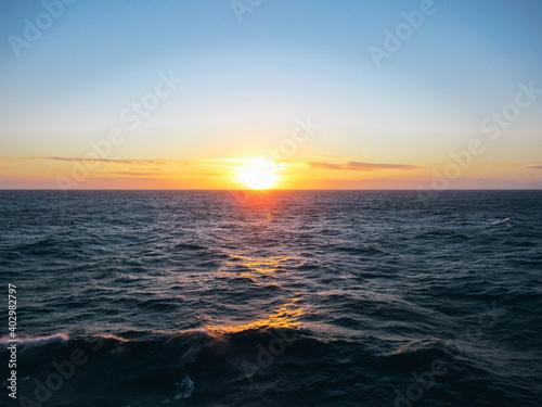 Sunset at sea with sunlight reflecting from waves.