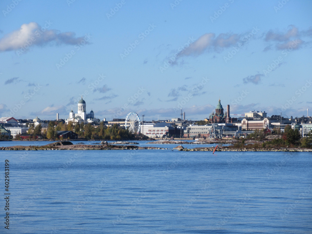 Helsinki city skyline panorama seen from the sea with a blue sky and cloud formations.