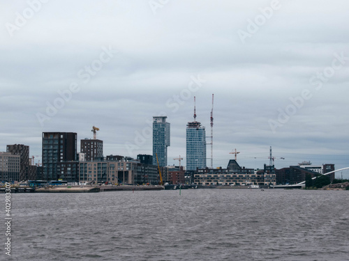 New apartment towers under construction in Helsinki shot from the sea on a cloudy day.