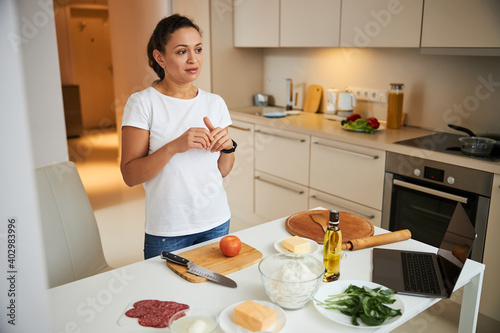 Thoughtful woman getting ready for making pizza