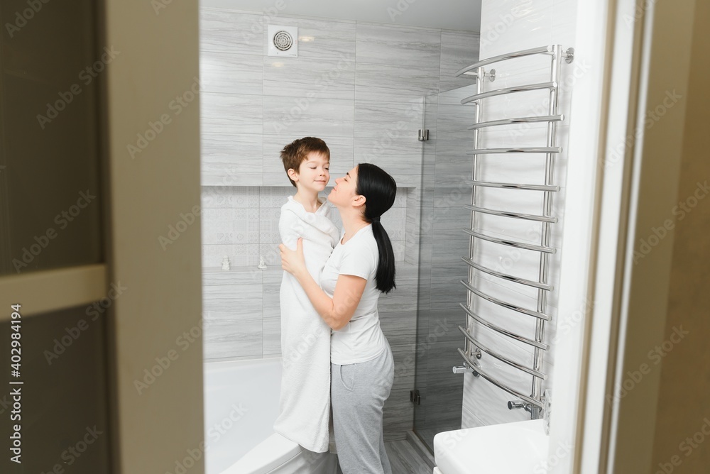 Mother washing little son in bathroom